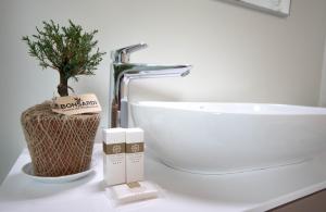 a bathroom with a sink and a plant on a counter at Hotel Nibaru in Porto Cervo