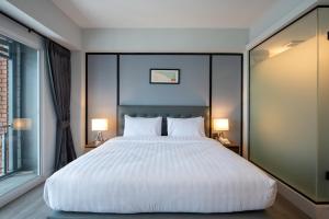 Postel nebo postele na pokoji v ubytování Mayson Place Hotel