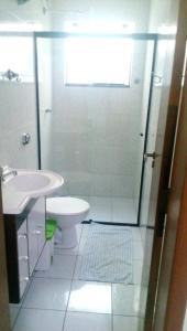 a bathroom with a shower and a toilet and a sink at Avenida Plaza Hotel in Pindamonhangaba