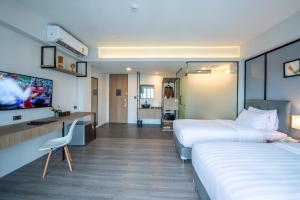 a hotel room with two beds and a flat screen tv at Mayson Place Hotel in Ban Phraek Sa