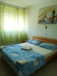 - une chambre dotée d'un lit avec des draps bleus et un tableau dans l'établissement Meje Apartments, à Split