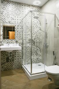 ein Bad mit einer Dusche, einem WC und einem Waschbecken in der Unterkunft Andersen Hotel in Dombai