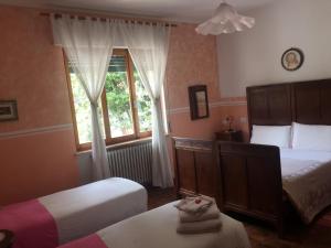 a bedroom with two beds and a window at Il Caslett in Villa Guardia