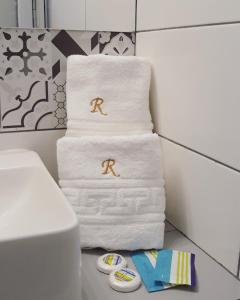 a pile of towels with the r on them in a bathroom at RIMA Del Mar in Eforie Nord