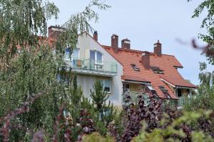 Biały dom z czerwonym dachem w obiekcie Apartament Słoneczny 1 w mieście Opole