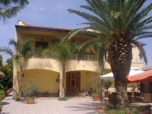a house with a palm tree in front of it at B&B Valoroso Village in Licata