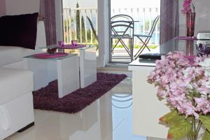a living room with two tables and a balcony at Apartment Siesta in Cavtat