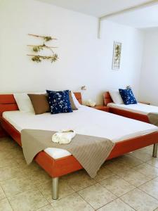 1 dormitorio con 2 camas y almohadas azules en Apartments Off, en Supetar