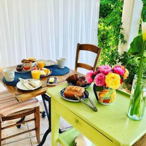 a table with breakfast foods and flowers on it at Les Arums de Sanguinet in Sanguinet