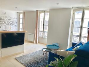 a living room with a blue couch and a tv at L'Escale au Coeur du Vieux Port de Marseille in Marseille