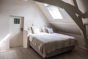 een slaapkamer met een bed en een dakraam bij B&B Gitsdal in Hooglede