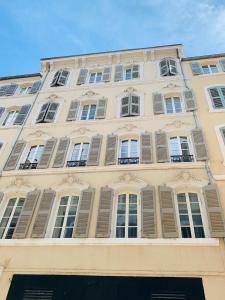 a tall building with windows and shutters on it at L'Escale au Coeur du Vieux Port de Marseille in Marseille