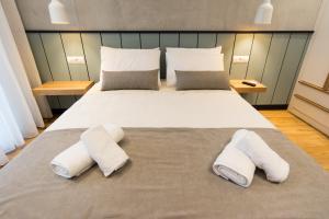 a bedroom with a large bed with two towels on it at Pleasant Stay in Kavala