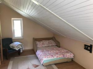 ein kleines Schlafzimmer mit einem Bett und einem Fenster in der Unterkunft Dom nad Jeziorem Zdworskim in Matyldów