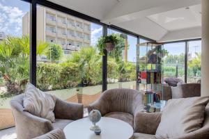 a room with chairs and a table and windows at Hotel Nevada in Bellaria-Igea Marina
