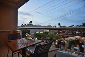 a balcony with a table and chairs and a view of a city at 24 Seven Boutique Hotel in Malia