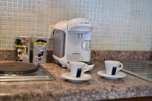 a coffee maker and two cups on a counter at 24 Seven Boutique Hotel in Malia