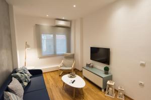 sala de estar con sofá azul y TV en Pleasant Stay en Kavala