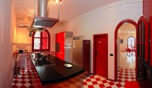 a kitchen with red cabinets and a black counter top at Villa Lulu in Schiavonea