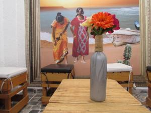 a vase with flowers on a table in a room at Hotel Diamonds in Ríohacha