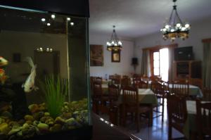 a dining room with a fish tank and a dining table at Effie Hotel in Skala