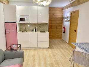 a kitchen with white cabinets and a pink refrigerator at Garnica5 Suites in Torrelavega