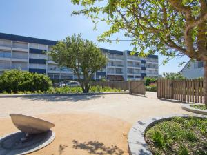 a large stone bowl in a courtyard with a building at Apartment Kérabus-1 by Interhome in Quiberon