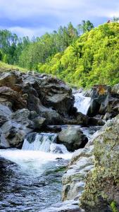 un río con rocas y cascadas en Estancia San Miguel en Villa Yacanto