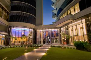 a large building with a lawn in front of it at Majestic Arjaan by Rotana – Manama in Manama