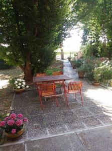 een picknicktafel en twee stoelen en bloemen bij gambisa street in Soliera