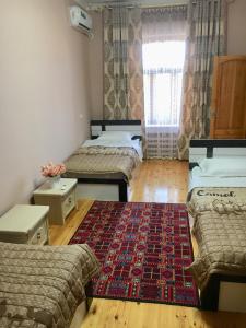 a room with three beds and a rug on the floor at Brown Hill in Samarkand