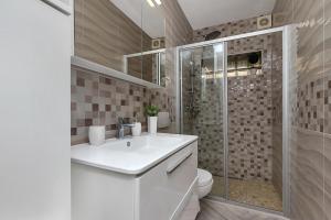 a bathroom with a white sink and a shower at Apartment Rita in Makarska +10 photos