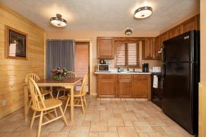a kitchen with a table and a black refrigerator at Flat Creek Inn in Jackson