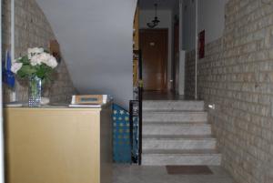 a hallway with a brick wall and stairs with a vase of flowers at 85 m² Apartments New Panorama (under new management) in Paralio Astros