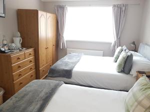 A bed or beds in a room at Swandale Guest House 