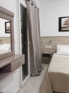 1 dormitorio con espejo, 1 cama y vestidor en Palaiokastro view en Kárpatos