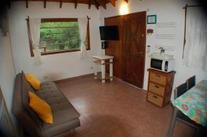 a living room with a couch and a microwave at Cabañas Cerca Delmar in Mar Azul