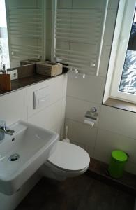 a bathroom with a white toilet and a sink at Ferienzimmer Segeberg in Bad Segeberg