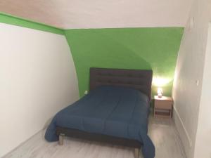 a bed in a room with green and white walls at Auberge de Cadenas in Veyreau