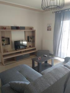 salon z kanapą i stołem w obiekcie Fotini's Apartment w mieście Néa Péramos