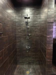 a bathroom with a shower with brown tiles at Loft Batumi in Batumi +20 photos