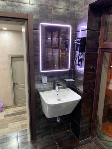 a bathroom with a white sink and a mirror at Loft Batumi in Batumi