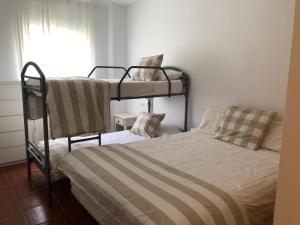 - une chambre avec 2 lits superposés et une fenêtre dans l'établissement Las Dunas De Islantilla, à Islantilla