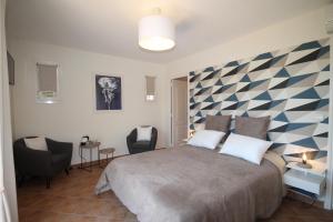 a bedroom with a large bed with a checkered wall at La Dolce Vita Opio in Opio