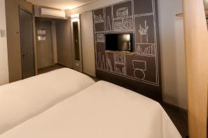 um quarto com uma cama e uma parede com desenhos em ibis Juazeiro do Norte em Juazeiro do Norte