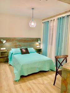 a bedroom with a blue bed and a chair at Garnica5 Suites in Torrelavega
