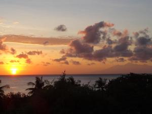 una puesta de sol sobre el océano con la puesta de sol en Sinar Bali 2, en Amed