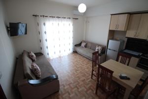 pequeña sala de estar con sofá y cocina en Doka Center Apartments, en Sarandë