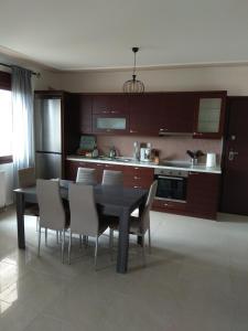cocina con mesa de comedor y sillas en Fotini's Apartment en Néa Péramos
