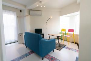 sala de estar con sofá azul y 2 sillas en Dazaifu - Apartment / Vacation STAY 36901 en Dazaifu